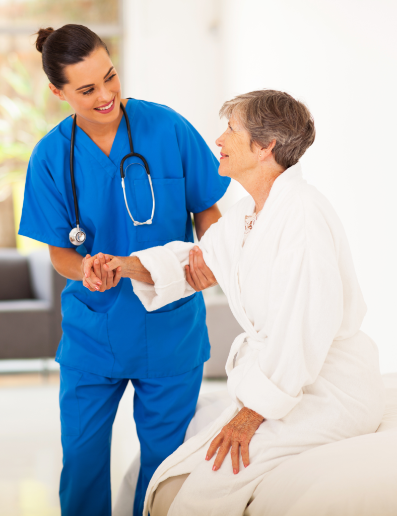 Care worker assisting an elderly woman to stand during safer people handling training